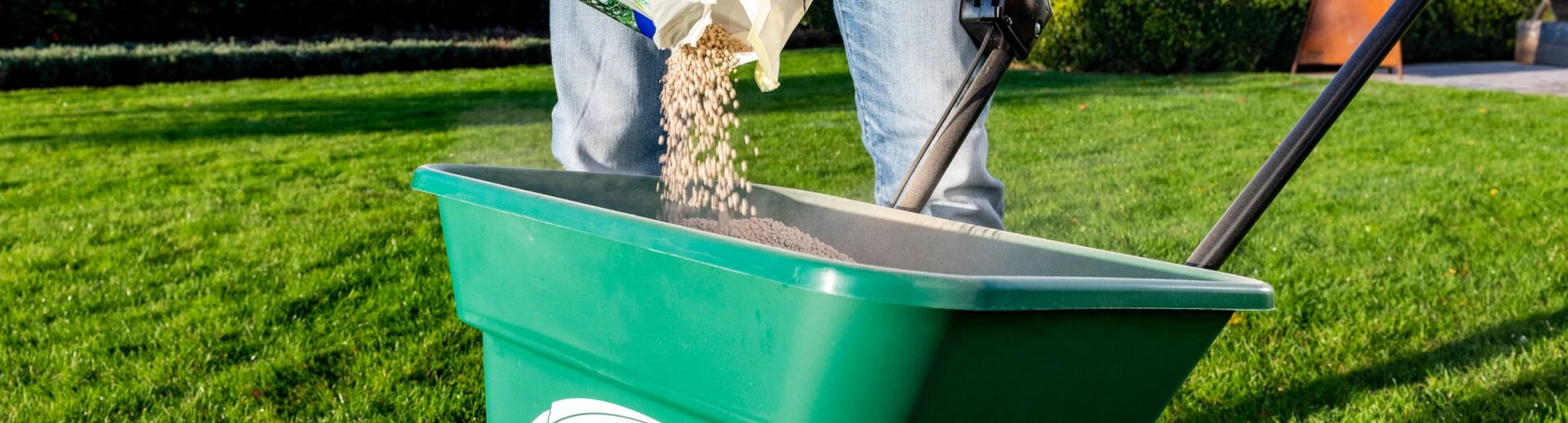 Foto van een gazon dat gekalkt wordt voor optimale pH-waarde, met een robotmaaier in actie die scherpe maaimesjes gebruikt voor een strak gemaaid gras.